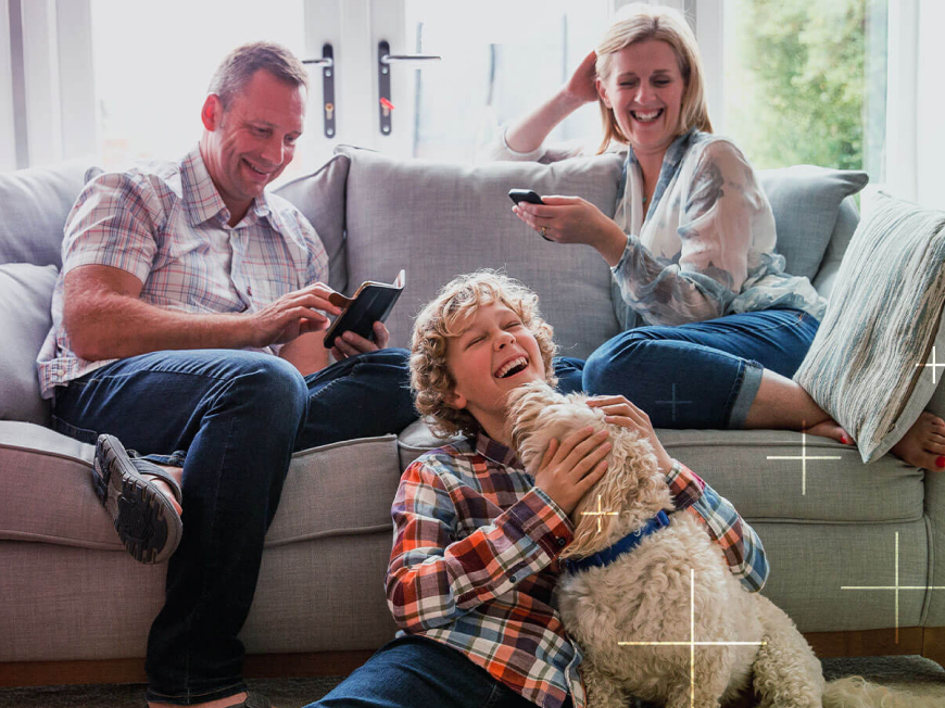 Family sitting on sofa with a dog
