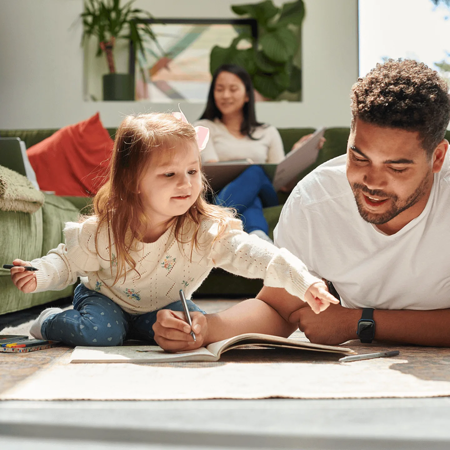 Father and daughter looking at book together