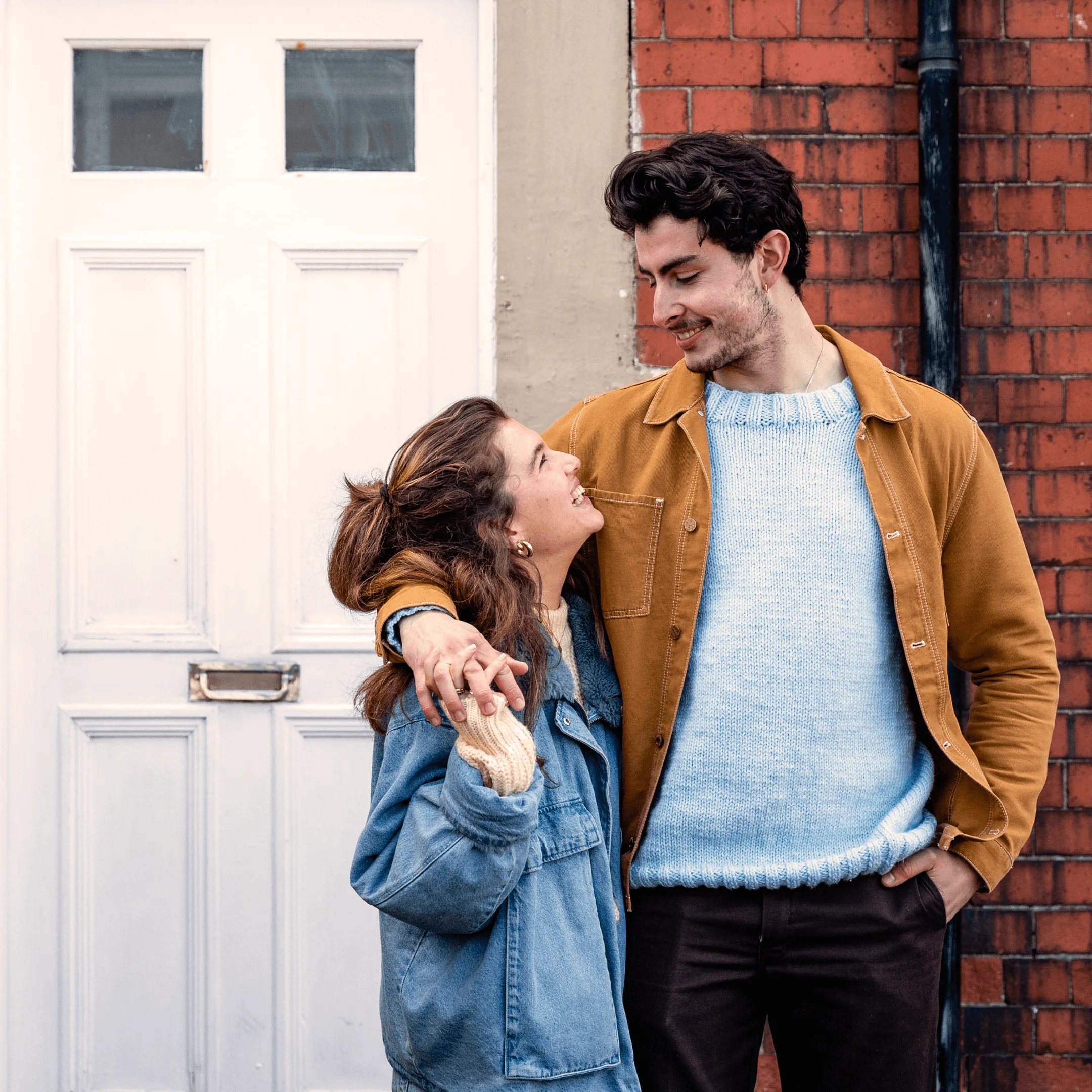 A young couple outside a the front of a house