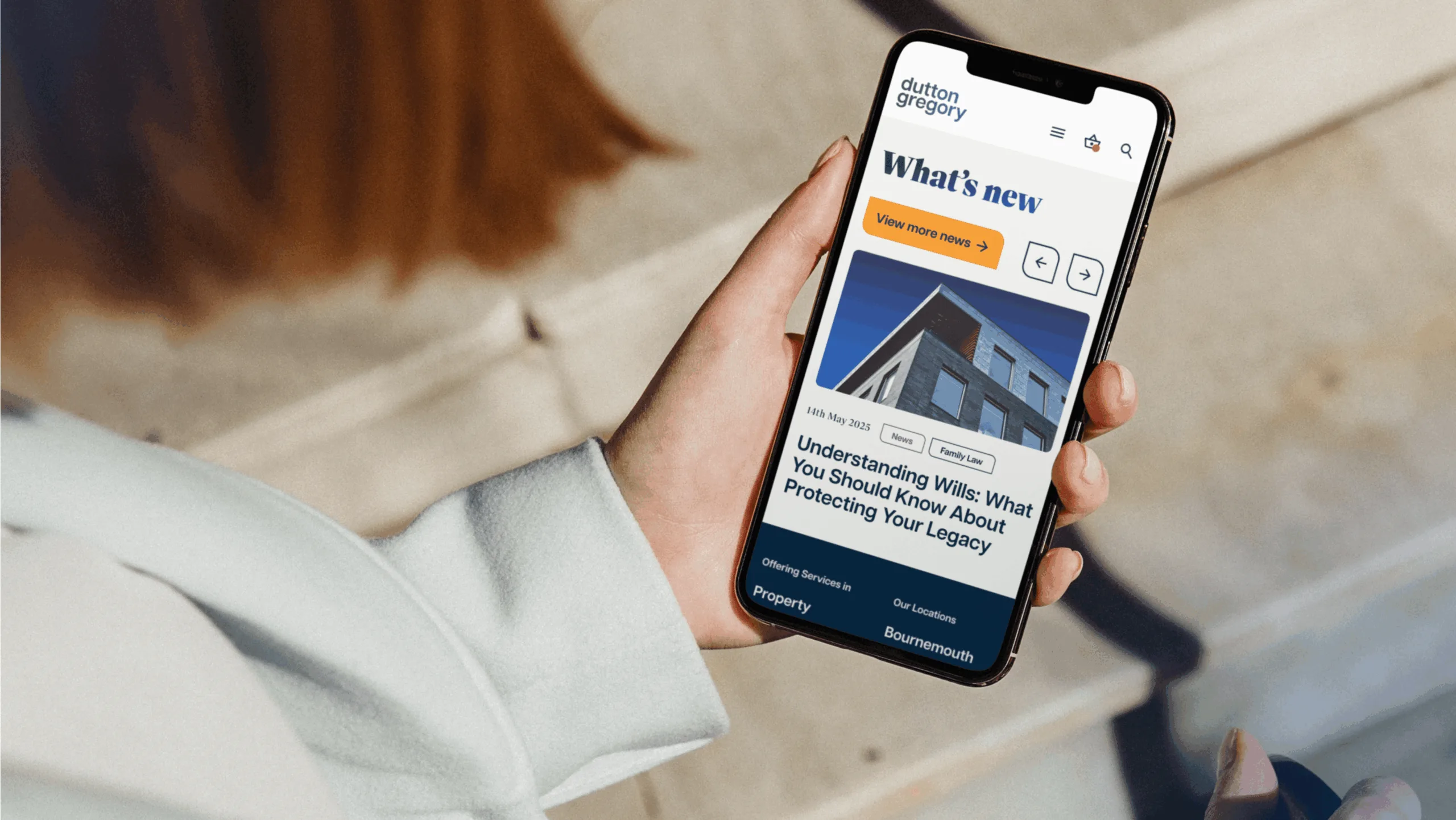 Woman holding phone looking at the Dutton Gregory website